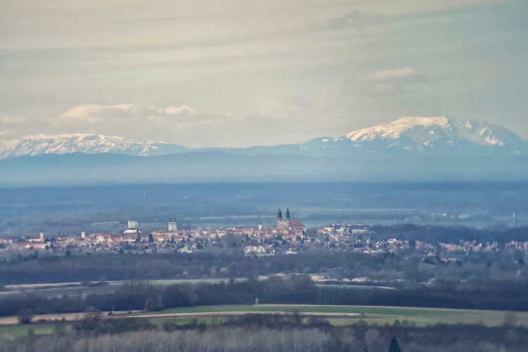 Gyönyörű felvételen látható Pápa városa és az Alpok havas hegyvonulata